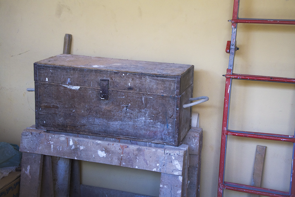 Tem uma caixa de madeira e uma escada de ferro